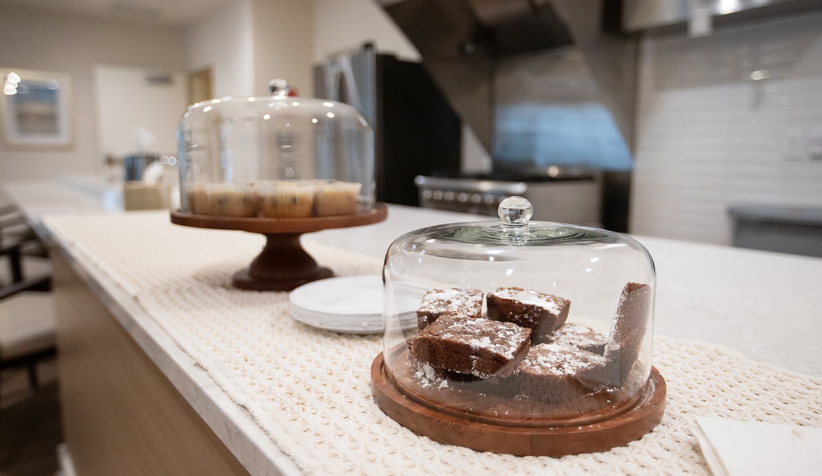 A countertop displaying two dishes of brownies and a delicious cake, ready for dessert lovers to enjoy.
